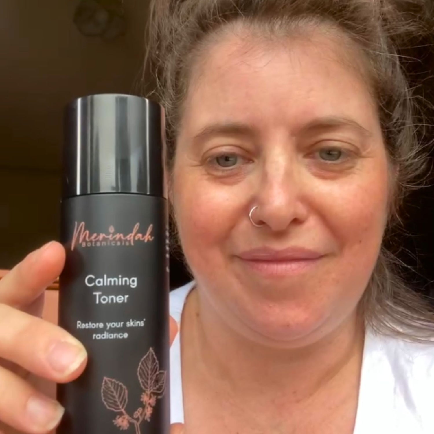 Woman holding hydrating face toner