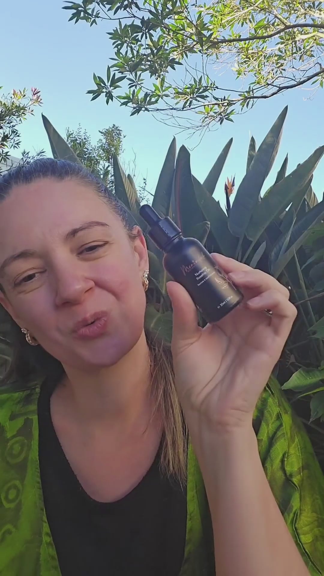 Woman applying Merindah Botanicals rosehip oil to face