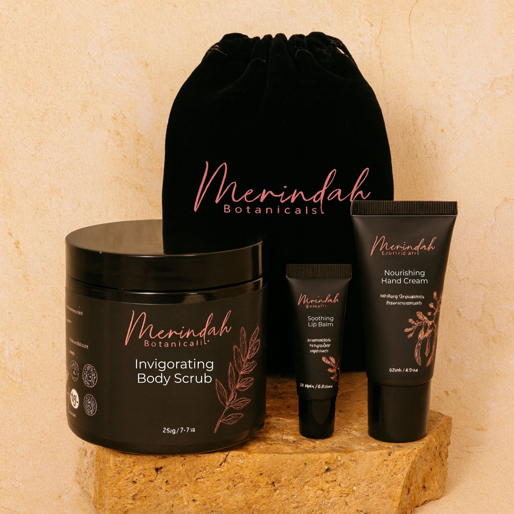 a black jar, lip balm tube, hand cream tube and velvet drawstring bag which is part of Merindah Botanicals&