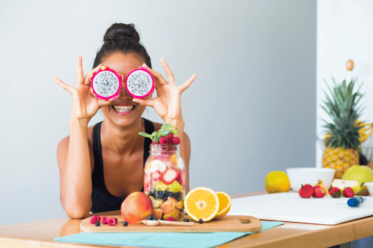 Smiling woman holding freshly cut summer fruits