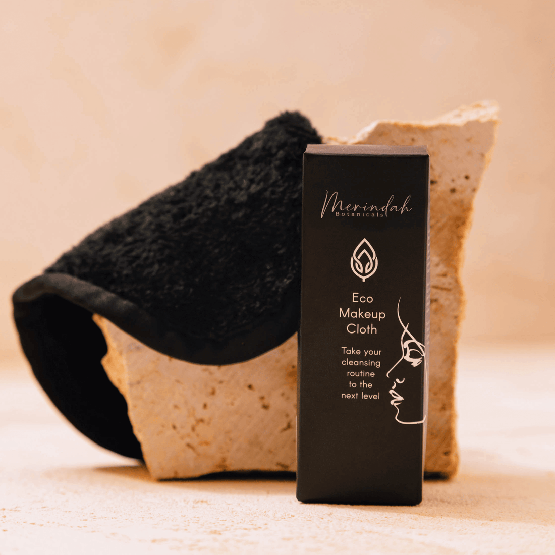 Eco Makeup Cloth and packaging box displayed on a stone surface — reusable makeup remover cloth made from soft black microfibre.
