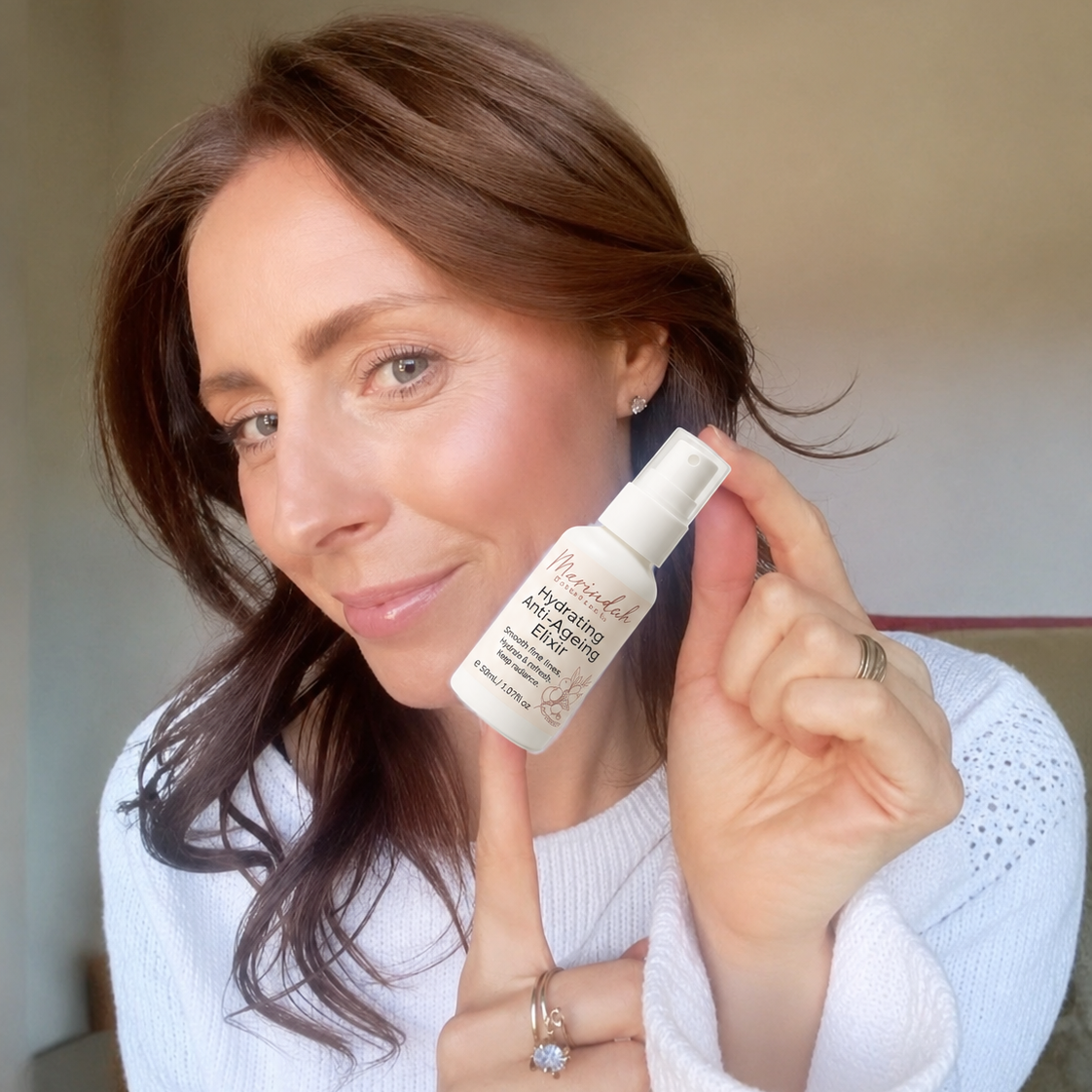 Woman holding a bottle of skincare product in a casual setting